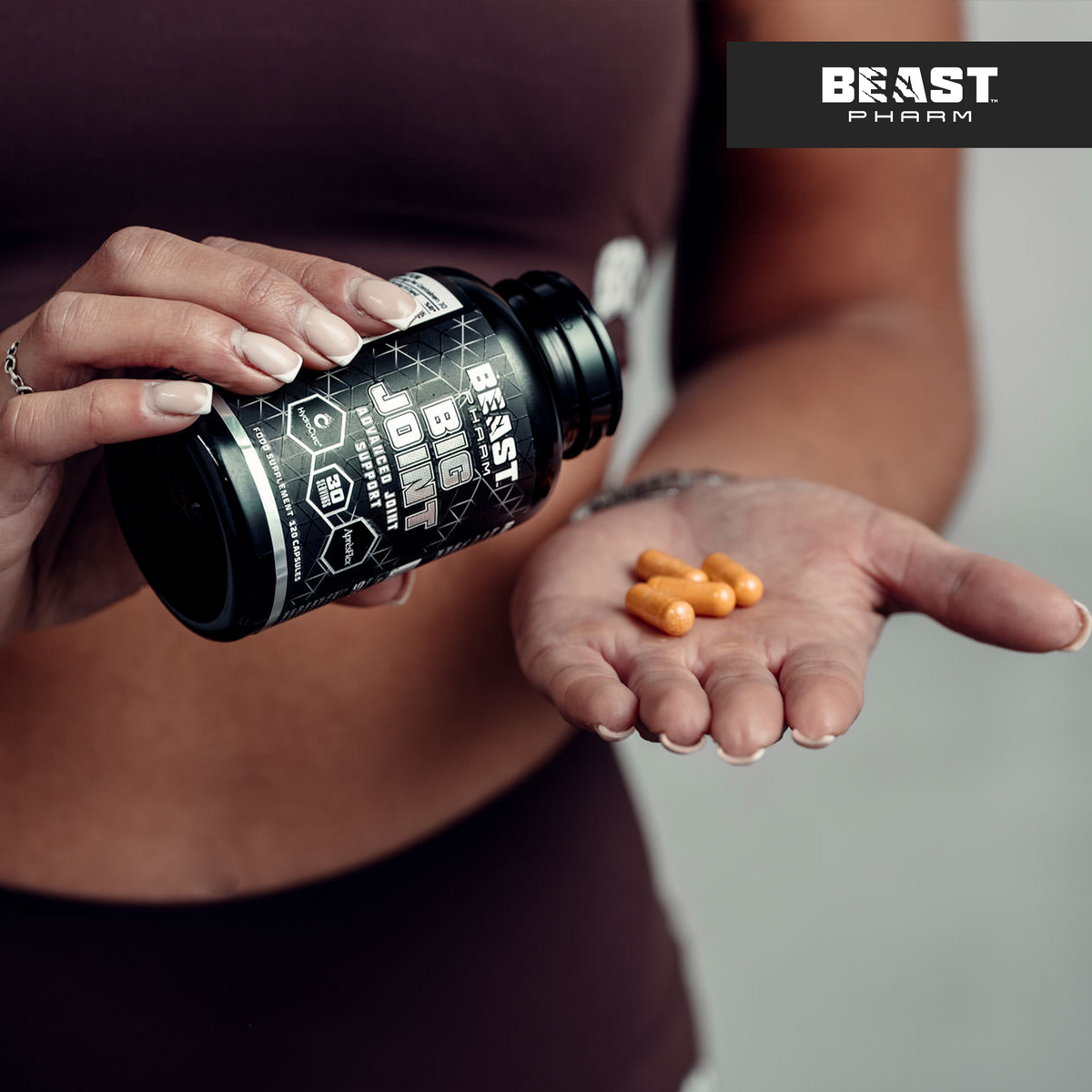 Hand holding Beast Pharm BIG JOINT bottle with capsules visible
