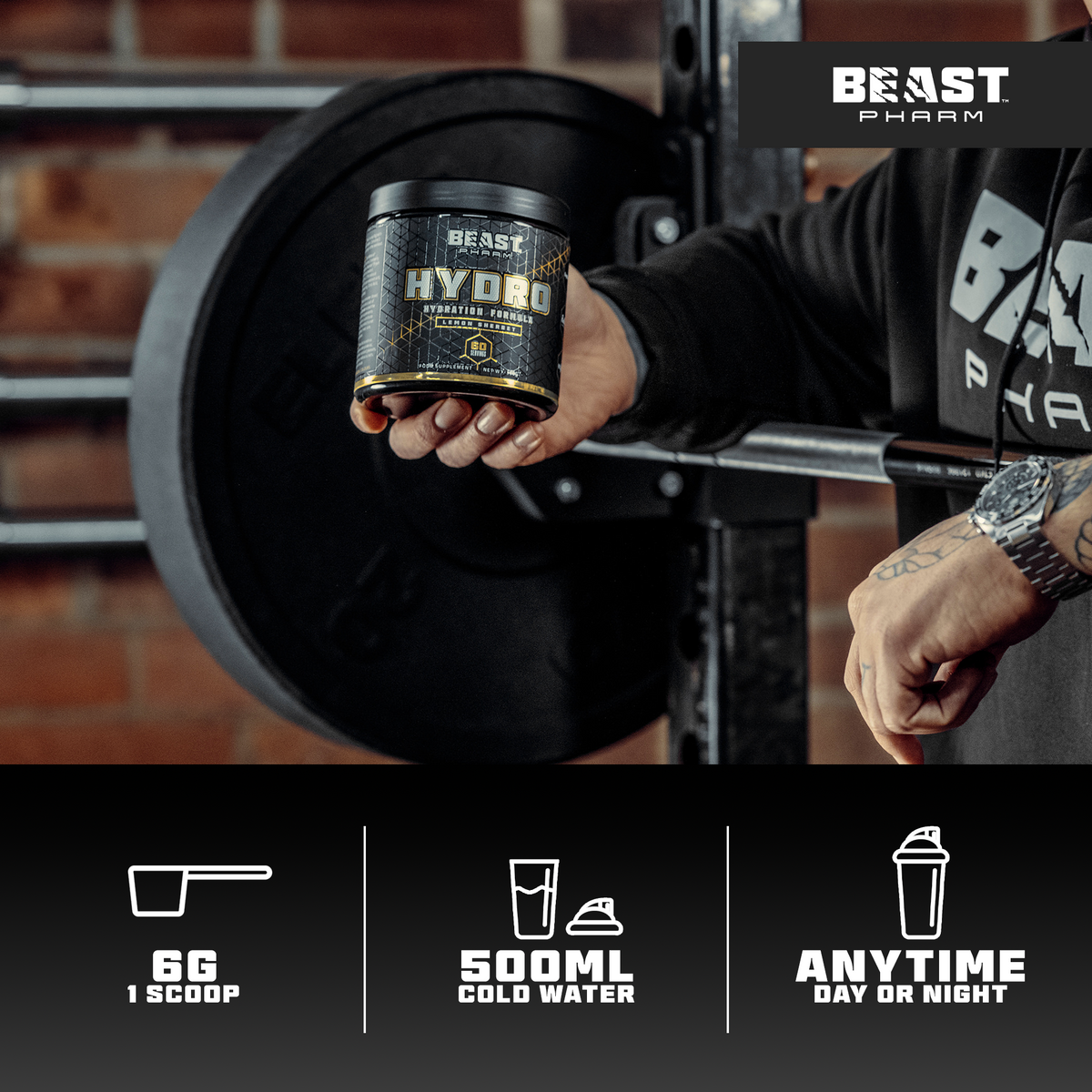 Person holding a Beast Pharm Hydrolyzed Protein Powder container with gym equipment in the background